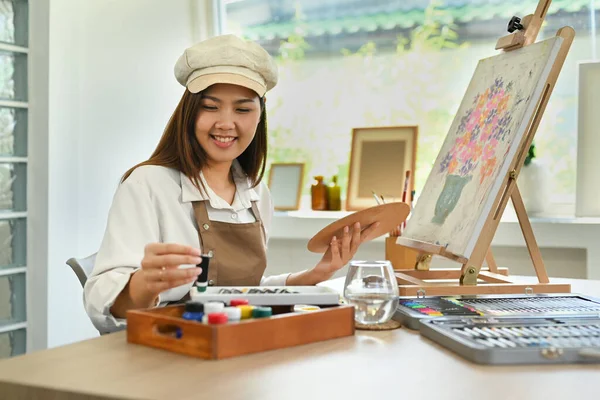 Pretty young woman creating artwork with watercolor, enjoy creativity activity at home. Art and leisure activity concept.