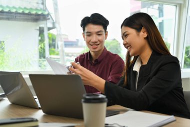 Gülümseyen iş kadını yeni projeyi açıklıyor ve iş arkadaşıyla kurumsal iş planını tartışıyor.