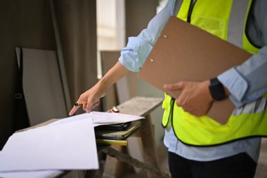 İnşaat alanını teftiş eden yansıtıcı ceketli mühendis görüntüsü..