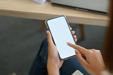 Close up view of woman using mobile phone at her workplace. White empty screen for your advertise design.