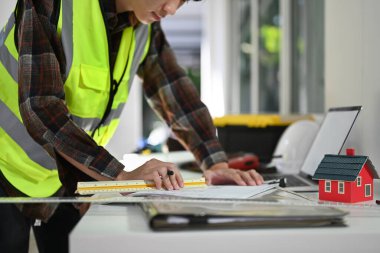 Cropped shot of engineers working with blueprints, planning development details at construction site.