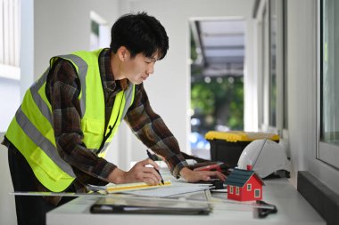 Engineers man working with blueprint, examining plans at construction site. Industry, Engineer, construction concept.
