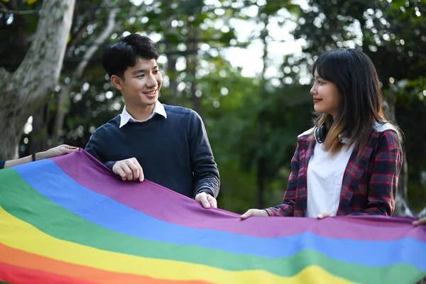 Lgbtqの誇りを支持する若い活動家たちはプライドの虹の旗を背中に振っている Lgbtコミュニティと誇り高い同性愛の概念 — ストック写真
