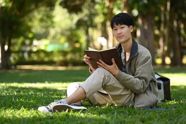 Pleasant Asian Man Reading Favorite Book Green Meadow Beautiful Summer — Zdjęcie stockowe
