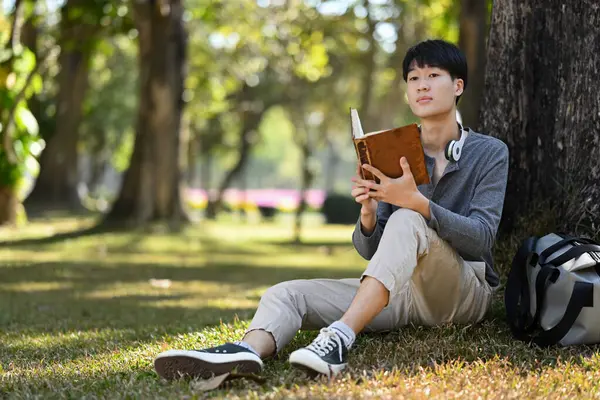 Young Asian Man Student Reading Interesting Book Spending Time Pleasure — Zdjęcie stockowe