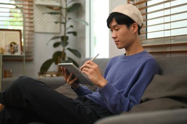 Image of stylish man browsing Internet or checking social networks on digital tablet. People and technology concept.