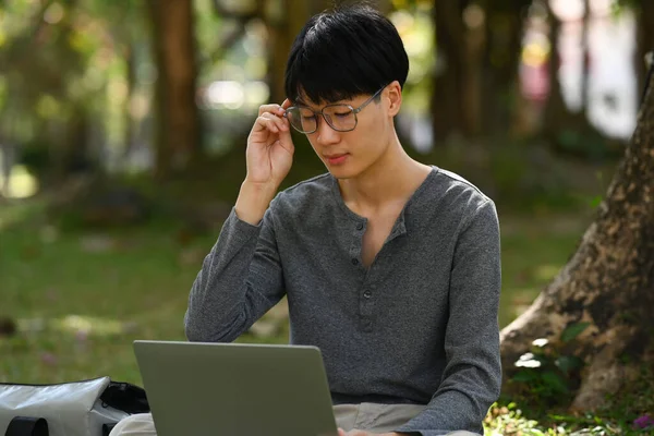 Smart Asian Student Man Doing Homework Using Laptop Calm Nature — Zdjęcie stockowe