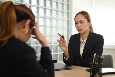 Öfkeli kadın yönetici, kötü iş sonuçları alan genç ve hayal kırıklığına uğramış çalışanı azarlıyor. Duygusal baskı, işte stres..