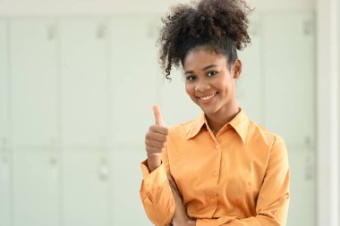 Image of beautiful African American woman showing thumbs up and looking confidently to camera.