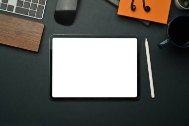 Boş ekranlı düz tablet, stilus kalem, not defteri ve siyah deri üzerine kahve fincanı..