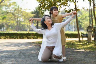 Gülümseyen orta yaşlı bir kadın ve küçük bir torun hafta sonu tatilinin tadını çıkarıyorlar..