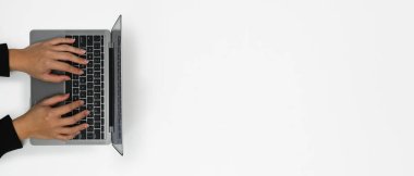 Dizüstü bilgisayarda yazı yazan adamın panoramik görüntüsü beyaz arka plan borçlu. Metin bilgisi veya reklam tasarımı için boşluk kopyala.