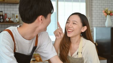 Genç ve neşeli bir çift modern mutfakta eğleniyor, hafta sonlarını birlikte geçiriyorlar..