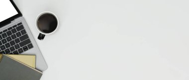 White office desk with laptop, notebooks and cup of coffee. Top view with copy space for text information or content.