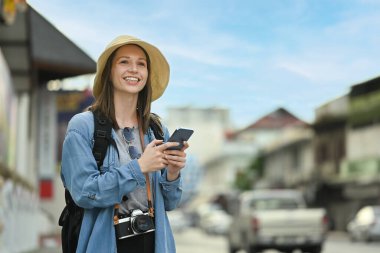 Caucasian female traveler using smart phone and waiting for cab for transporting. Tourism and transportation concept.