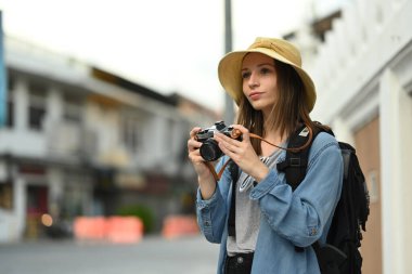 Pretty caucasian female traveller with backpack walking in old city in Chiang Mai Northern Thailand.