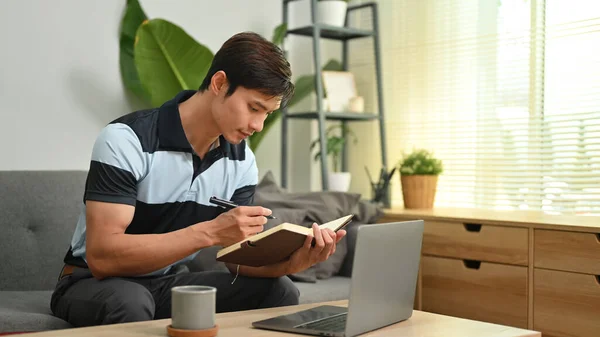 Millennial Man Using Laptop Making Important Notes Notepad Working Online — Fotografia de Stock