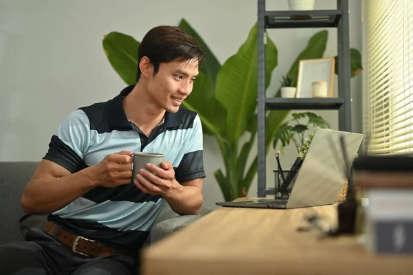 Handsome Asian Man Drinking Hot Coffee Watching Video Laptop Computer — Fotografia de Stock