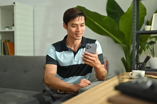 Smiling Millennial Man Checking Social App Her Smart Phone While — Fotografia de Stock