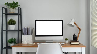 Modern workplace, home office interior with blank computer screen on wooden desk. Empty screen for your advertising design.