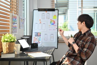 Image of creative male web designer planning application development for web mobile phone at modern workplace.