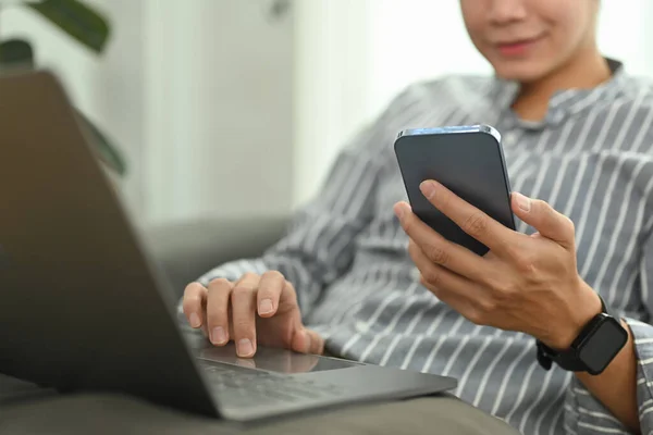 在社交网络上用智能手机聊天 在家里用笔记本电脑聊天的男人 — 图库照片