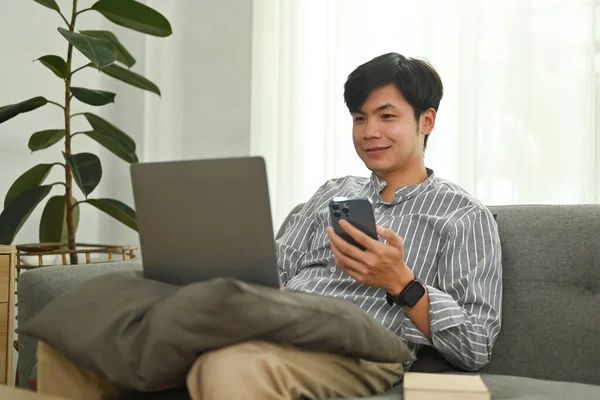 Vrolijke Aziatische Man Hand Houden Van Mobiele Telefoon Kijken Naar — Stockfoto