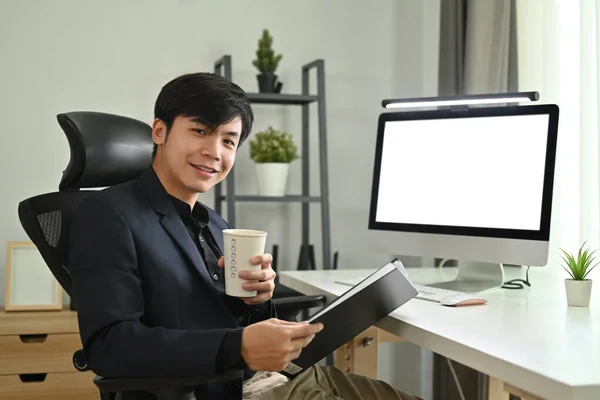 亚洲男性初创时拿着咖啡和粘合剂坐在现代办公室的画像 — 图库照片