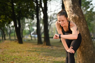 Sportif bir kadın idmandan sonra nabzını ve nabzını kontrol ediyor. Sağlıklı yaşam tarzı, spor ve teknoloji kavramı.