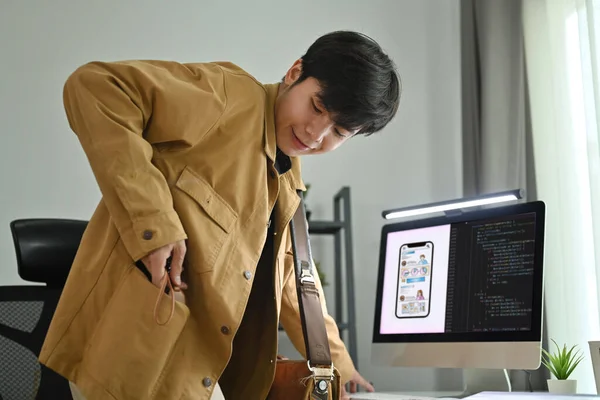 在创意办公室设计手机新应用框架的亚洲男性网页设计师微笑 — 图库照片