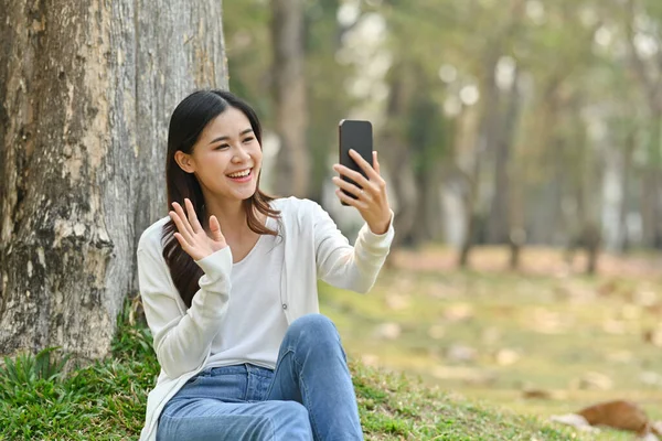 Güzel Asyalı Genç Bir Kadın Parktaki Bir Ağacın Altında Otururken — Stok fotoğraf