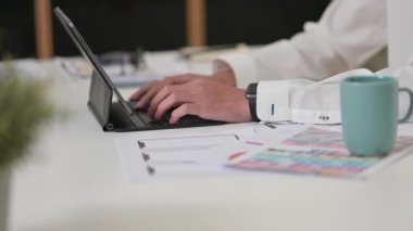 İnsan web sitesi geliştiricisinin dijital tablet klavyesine yazı yazması, modern ofiste çalışan tasarım projesi.