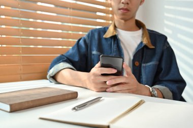 Kot ceketli hippi adam sosyal medya interneti okuyor ya da ofis telefonunda cep telefonuna mesaj yazıyor..