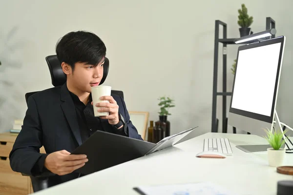Takım Elbiseli Asyalı Işadamı Kahve Içiyor Ofiste Çalışırken Bilgisayar Monitörüne — Stok fotoğraf