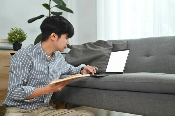 Millennial Άνθρωπος Κρατώντας Σημειωματάριο Και Χρήση Φορητού Υπολογιστή Στο Σαλόνι — Φωτογραφία Αρχείου