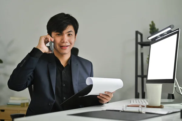 穿着黑色西装 面带微笑的男性创业者在处理办公室报告时打电话的肖像 — 图库照片