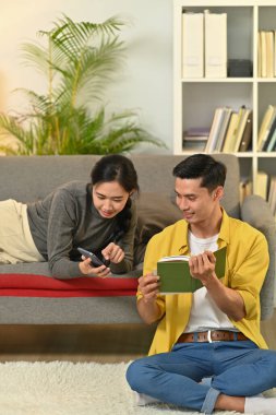 Mutlu evli genç çift kitap okuyor, hafta sonları evde eğleniyor..