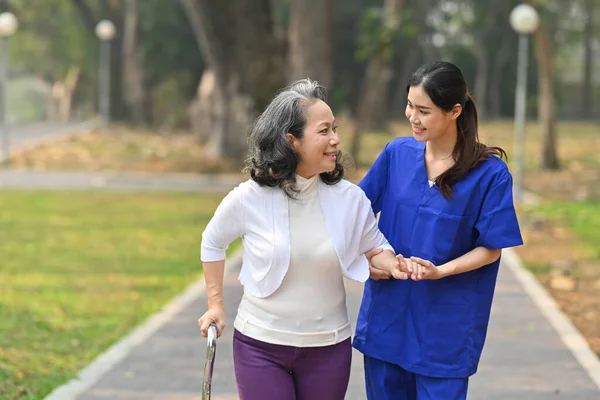 Friendly Female Nurse Assisting Elderly Woman Nursing Home Park Assistance — Stock Photo, Image