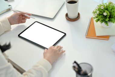 Yukarıdan bakıldığında profesyonel iş kadınının araştırma yaptığı, dijital tabletle çalışma masasında gezindiği görülüyor..