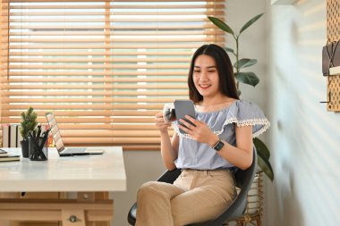 Neşeli genç bir kadın mesaj atıyor, akıllı telefondan sohbet ediyor..