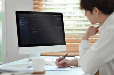 Kodlama programcısı, yazılım mühendisi masada oturuyor, yazılım geliştirme ofisinde çalışıyor..