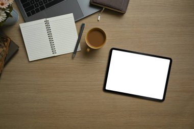 Düz konum, dijital tablet, kahve fincanı, not defteri ve dizüstü bilgisayar ahşap masada. Reklam metniniz için boş ekran. 