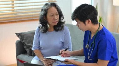 Pratisyen adam tedaviyi açıklıyor, ev ziyareti sırasında olgun kadın hastalara tavsiyelerde bulunuyor..