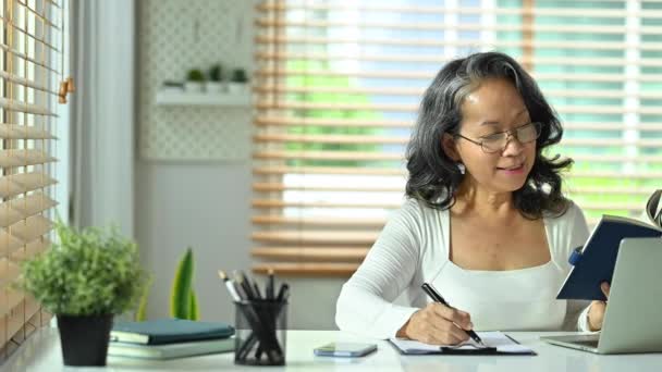 Σοβαρή Γυναίκα Γυαλιά Κρατώντας Σημειώσεις Στο Σημειωματάριο Και Εργάζονται Φορητό — Αρχείο Βίντεο