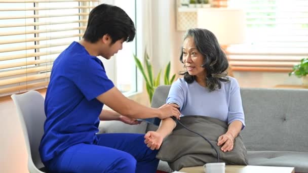 Opiekun Mierzący Tętnicze Ciśnienie Krwi Starszy Pacjent Sfigmomanometrem Podczas Wizyty — Wideo stockowe