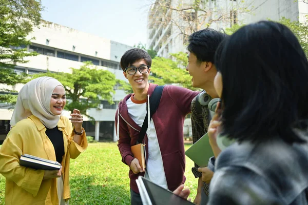 stock image Multiethnic group of cheerful university student talking to each other after classes while walking in campus outdoors.