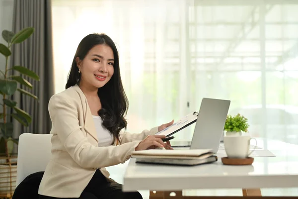 漂亮的亚洲女企业家坐在现代办公室工作台前的笔记本电脑前 — 图库照片