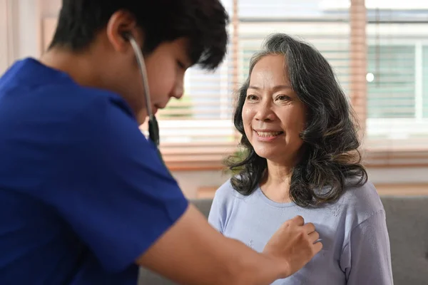 ホームケア訪問中に医師が高齢女性の心臓や肺をチェック聴診器を保持 高齢者医療の概念 — ストック写真