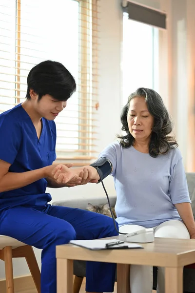 家庭訪問中に血圧の中年女性を測定健康訪問者 ヘルスケアとホームヘルスケアサービスの概念 — ストック写真