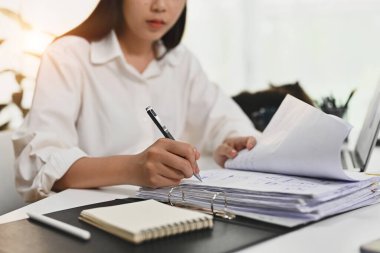 Muhasebeci kadın muhasebe analisti muhasebe belgelerinde çalışıyor, ofis masasında kontrat imzalıyor..